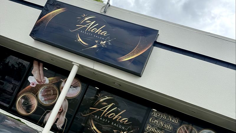 Aloha Beauty Salon storefront with black and gold window signs